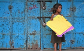 Yellow Patang. A girl from the nearby slum collecting fallen kites (patang) at Manek Chowk in the Old City.