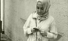 A young woman checks her smart phone