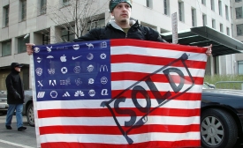 A protester holds Adbuster's American Corporate flag