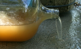 Dirty water spilling from a bottle, by Ildar Sagdejev
