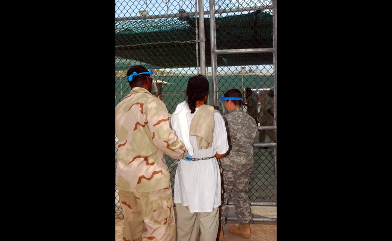 Guards escort a Guantanamo captive in chains to a recreational area