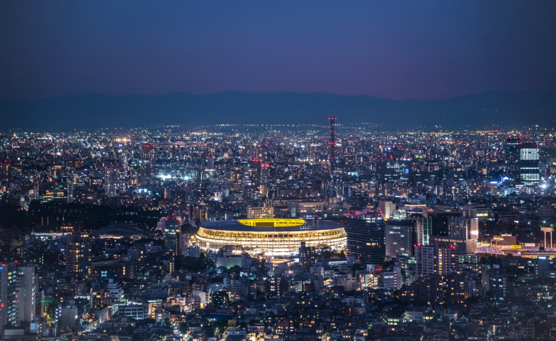 Overhead aerial view of the new National Stadium with Tokyo's skyline in twilight time, fully completed main stadium for Tokyo Olympic Summer Games 2020. Image via iStock.