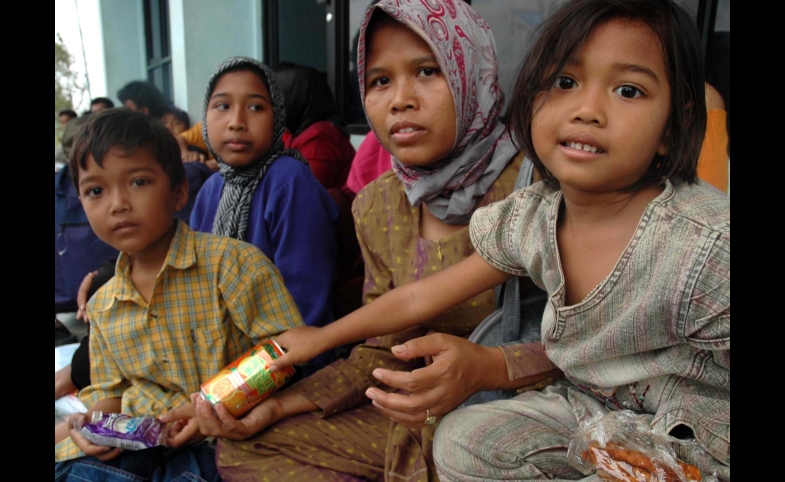 An Indonesia family waits for food from the U.S. Navy and IOM.