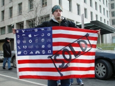 A protester holds Adbuster's American Corporate flag