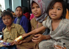 An Indonesia family waits for food from the U.S. Navy and IOM.