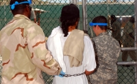 Guards escort a Guantanamo captive in chains to a recreational area