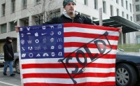 A protester holds Adbuster's American Corporate flag