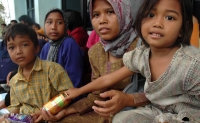 An Indonesia family waits for food from the U.S. Navy and IOM.